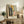 Contemporary expressionist wall art depicting an abstract figure positioned with a clock and bed in a psychological interior scene, rendered in dark muted hues with haunting mood.