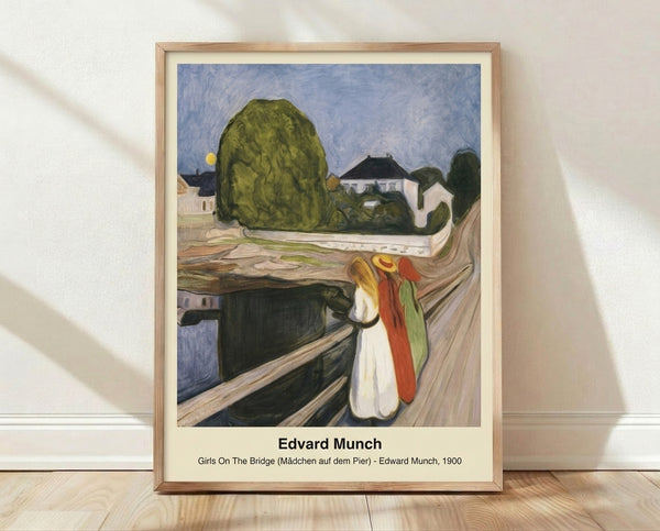 Framed poster of Girls On The Bridge by Edvard Munch, featuring three female figures in period dress standing on a wooden bridge, rendered in muted earth tones and soft blues with an impressionistic style and contemplative, slightly unsettling mood.