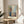 Framed artwork presenting a psychologically charged scene of self-examination, executed in expressive brushstrokes with a restrained palette of grays, ochres, and muted tones.