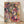 Abstract splatter art print in vibrant pink and yellow with black accents and blue highlights, creating an energetic and dynamic composition on a cream background.