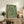 Framed abstract poster displaying gentle arching strokes in forest and light green hues on neutral background, capturing a meditative and balanced modernist vision.