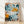 Abstract graffiti poster featuring vibrant spray paint marks, geometric shapes, and a barcode design in light blue, orange, terracotta, and teal on white background, framed on wall.