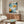 Contemporary abstract graffiti poster combining retro spray paint style, dynamic shapes, and barcode imagery in a bold palette of light blue, terracotta, orange, and dark teal.