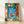 Modern minimalist poster featuring an abstract poolside scene with coral and red-orange swimmer silhouettes, cobalt blue water, and lush forest green botanical elements, evoking a serene summery escape.