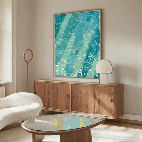 Peaceful coastal wall art depicting a solitary surfer on rolling waves in soothing teal and turquoise tones with minimalist watercolor styling and coral accents.