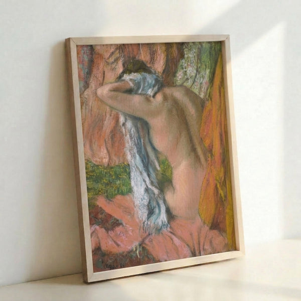 Framed wall art showing a woman in profile drying her neck, capturing a quiet moment of repose with Degas's signature soft color palette and graceful figure study.