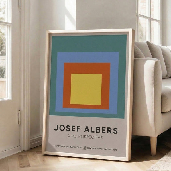 Abstract geometric composition of nested squares in muted blue, orange, and yellow hues; framed Bauhaus-style art print with meditative aesthetic.
