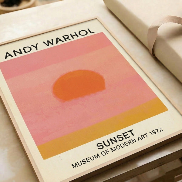 Framed minimalist pop art print of a sunset in warm orange, peach, and golden yellow hues, evoking serenity and artistic warmth.