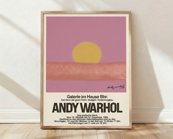 Pop art sunset poster with a large glowing sun in golden yellow and mauve pink tones against a minimalist horizon, framed wall art in modern style.