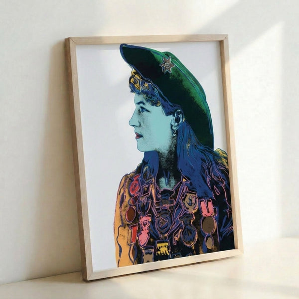 Colorful pop art portrait of Annie Oakley framed on wall, showing signature Warhol technique with vivid hues and simplified graphic forms from the iconic Cowboys and Indians collection.