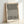 Minimalist framed wall art featuring interlocking black lines and cream tones that create a mesmerizing optical effect.