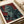 Heroic vintage wall poster in Bauhaus style depicting a warrior figure with armor and sword, rendered in moody deep red and slate gray palette.