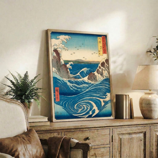 Vintage ocean art print in Japanese woodblock style: serene whirlpool composition with deep prussian blue waters, cream and turquoise accents, brown rocky coastline, and pale golden sky.