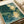 Japandi wall art print depicting a mystical nocturnal landscape where fireflies dance above a forest stream bordered by bamboo, rendered in soft cream, dark green, and gold hues.