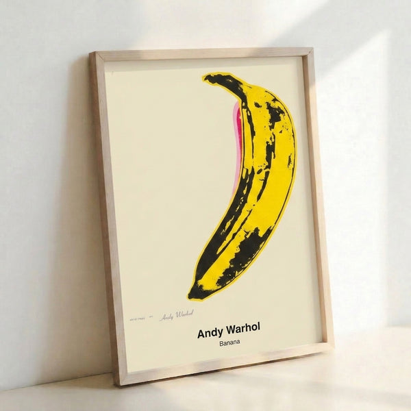 Warhol-inspired banana artwork in striking yellow with black outlines, modern pop art style poster framed on gallery wall.
