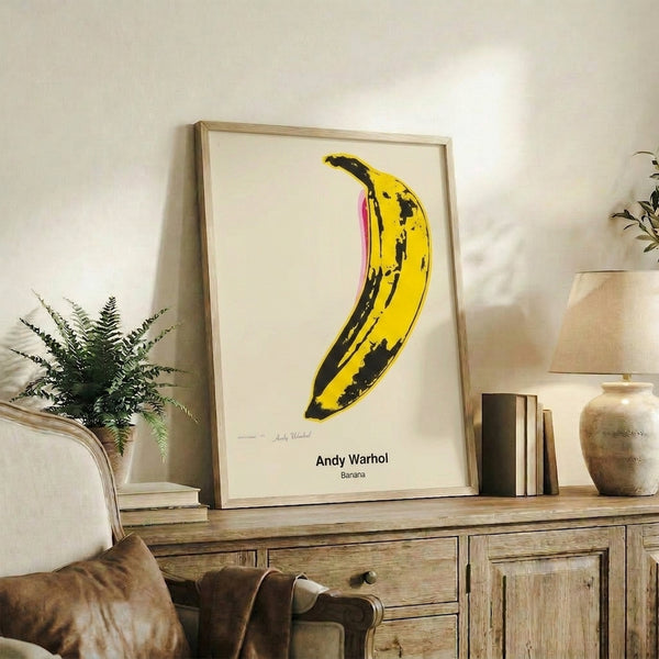 Yellow banana rendered in vibrant pop art aesthetic with black contours and white space, framed modern art print.