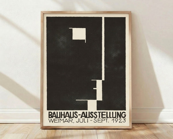 Bauhaus Ausstellung Weimar 1923 poster featuring bold geometric shapes in black and cream, framed on a wall as minimalist modern art.