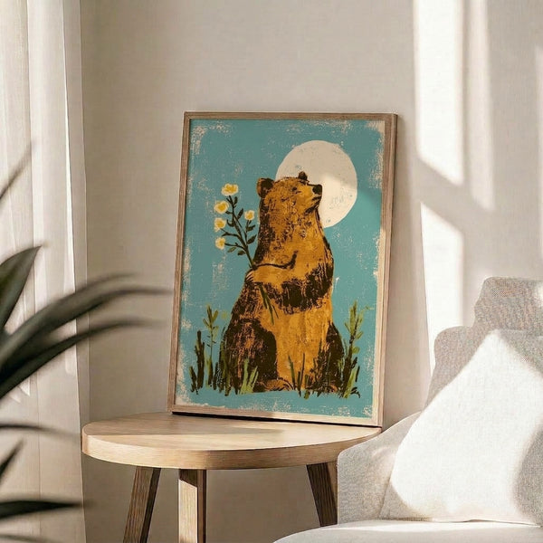 Contemplative bear gazing upward at a soft yellow moon with blooming wildflowers and grass in muted boho colors including teal and cream; retro folk art print on a wall.