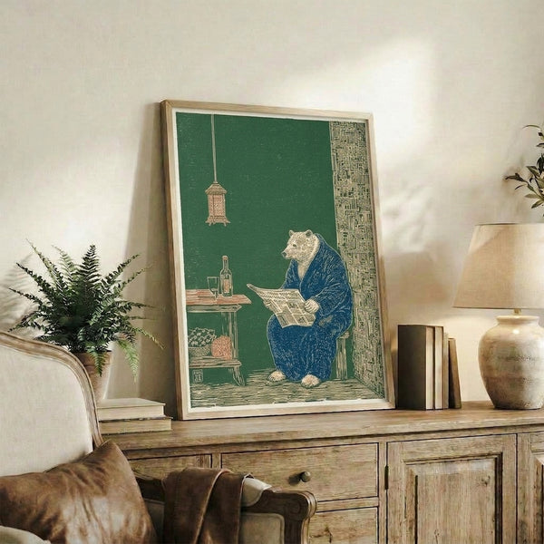 Vintage folk art print depicting a whimsical bear reading a newspaper while dressed in a kimono, surrounded by cozy domestic objects in sage, rust brown, and cream hues.