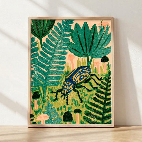 Framed linocut art print featuring a jewel beetle surrounded by ferns, mushrooms, and garden foliage in teal, cream, navy, and gold tones on a wall.