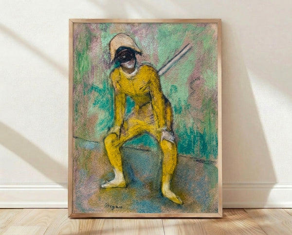 Framed poster of Degas' L'Arlequin Jaune featuring a figure in a vibrant yellow harlequin costume, rendered in soft pastel tones with warm ochres and muted earth colors.