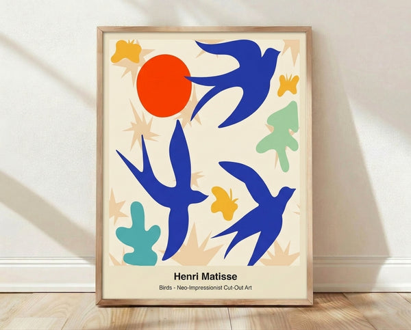 Abstract cut-out poster in cobalt blue, crimson red, and chartreuse green depicting stylized birds and organic shapes, framed on a wall.