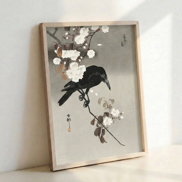 Framed Japandi art print showing a solitary crow amid flowering branches in soft cream and black tones, capturing the serene elegance of traditional Japanese botanical imagery.