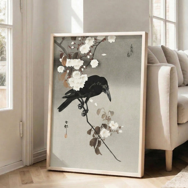 Japanese woodblock print depicting a crow on a blossoming branch with delicate foliage in muted cream, gray, and black palette; refined, contemplative wall art.
