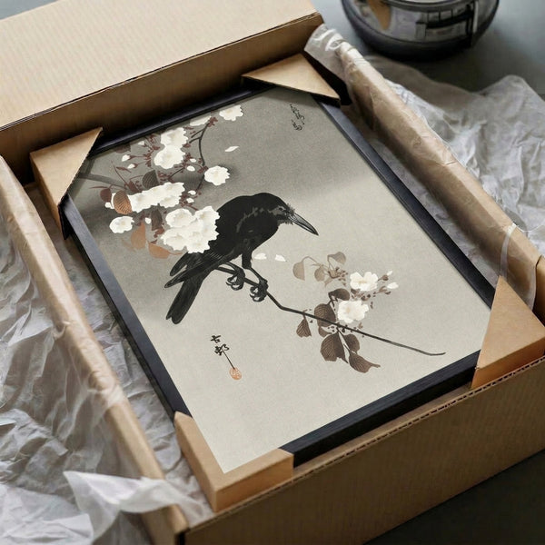 Serene Japanese woodblock-inspired print of a dark crow among blooming branches and foliage in understated cream, black, and gray; contemplative wall decor piece.