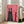 Contemporary surreal poster of a black cat figure embellished with bold red patterning and white linear details, mounted on wall with quirky dark energy.