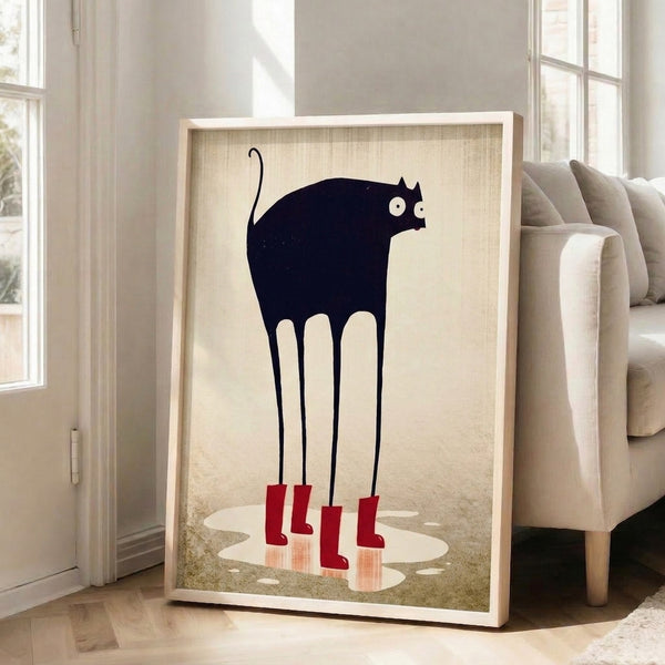 Framed line art print capturing a whimsical black cat in red rain boots mid-splash, rendered in minimalist style with a soft cream and taupe palette.