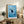 Contemporary wall art featuring a meditative black cat amid rippling water and fish shapes, executed in minimalist line style with cool blue palette.