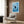 Framed minimalist poster depicting a contemplative black cat surrounded by water ripples and fish in a soothing blue and white line art design.