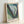 Modern abstract print showcasing layered petals in green and blue with charcoal accents, rendered in a flowing style that merges botanical and ethereal qualities.