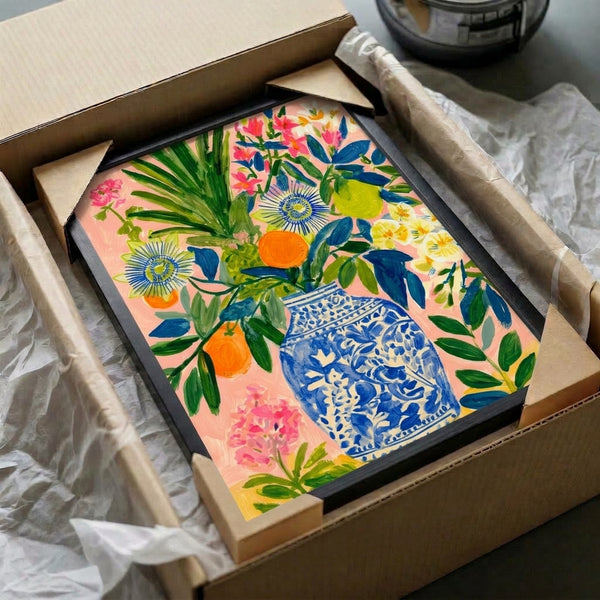 Japandi-inspired framed print depicting a decorative vase bursting with vibrant oranges, lemons, passion flowers, and foliage in modern boho colors.
