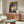 Monet's Le petit-déjeuner poster art depicting a peaceful garden breakfast moment with impressionist brushwork and a refined palette of pale greens and warm neutrals.
