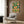 Garden-inspired wall poster in art nouveau aesthetic showing an orange monarch butterfly among coral flowers and teal-green foliage with serene, cottagecore mood.