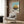 Enchanting anime poster featuring a soaring castle perched above clouds in a whimsical composition, rendered in soothing creams, teals, and olive green tones.