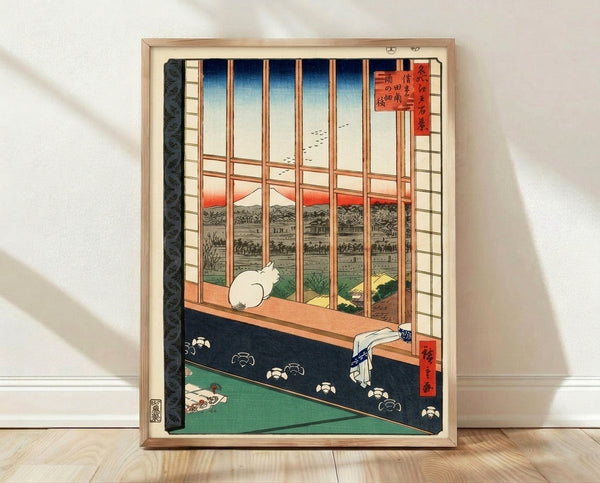 Serene Japanese woodblock print of an indigo cat gazing from a window toward misty mountains and blooming flowers in soft terracotta and cream tones, framed on a wall.