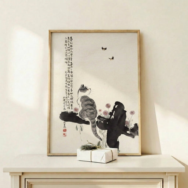 Framed print displaying a whimsical cat surrounded by butterflies and blooms in Japanese woodblock style, rendered in cream, black, and soft mauve hues.