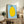 Lighthearted minimalist poster showing a smiling lemon with simple black outlines and green leaf accent against a pale blue wall art background.