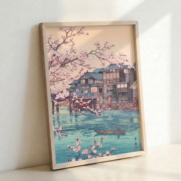 Poetic Japanese riverside composition featuring delicate cherry blossoms framing a teahouse and watercraft on a tranquil river, executed in traditional woodblock style with cream, pink, and sage palette.