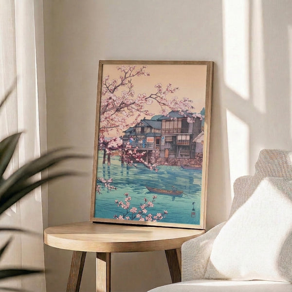 Calm, meditative woodblock-inspired print of cherry blossoms and a riverside teahouse scene with traditional boat, featuring pale pink, turquoise, and sage green brushwork.