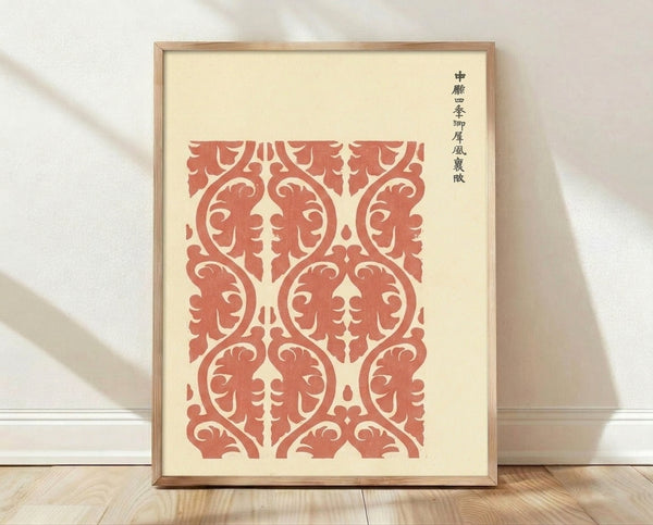 Framed Japanese woodblock textile pattern print in terracotta red and cream, featuring elegant scrolling ornamental motifs in a classical, orderly design.