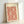 Cream and terracotta red Japanese woodblock print displaying an intricate classical textile pattern with flowing scroll ornaments in an orderly arrangement.