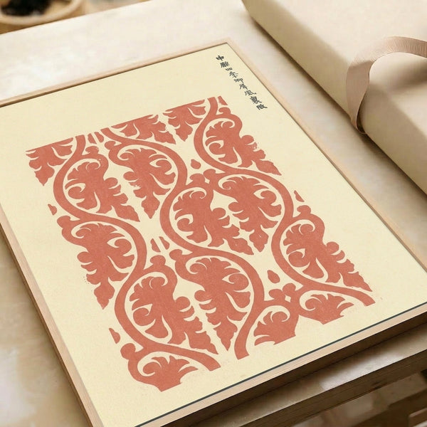 Framed art print in terracotta red and cream displaying a symmetrical Japanese woodblock textile pattern with classical scroll and decorative tile elements.