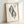 Scholarly woodblock-inspired poster showing a delicate ornamental leaf crest design in minimalist black linework on cream ground.