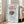 Minimalist framed poster depicting a simple coffee cup motif in earthy browns and vibrant red against a serene light blue field, ideal for sophisticated home interiors.