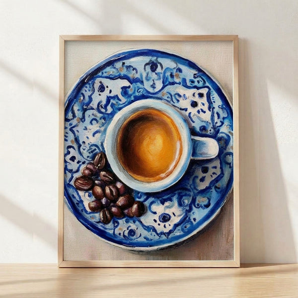 Watercolor still life poster featuring a cobalt blue coffee cup with golden orange accents, scattered coffee beans, and ceramic dishware in warm cream and brown tones, framed on a wall.
