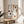 Framed minimalist poster with line art depiction of coffee cup, kettle, beans, and orange slice in warm neutral palette suggesting calm kitchen moments.